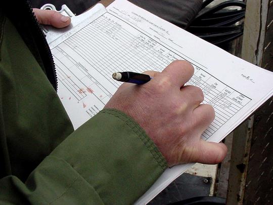 tight shot of check station data report being filled out November 2000